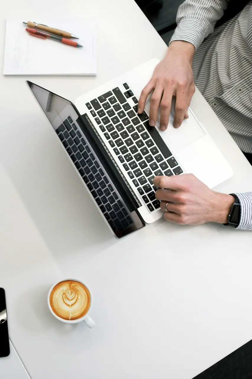 person using laptop on white wooden table